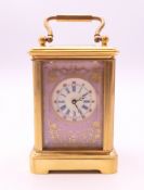 A miniature porcelain mounted carriage clock. 6 cm high.