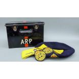 An A.R.P tin containing a cap and arm bands.