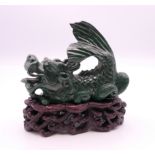 A malachite model of a dragon on a wooden base. 8.5 cm high overall, dragon 6.5 cm high.