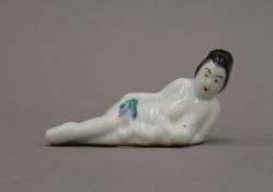 A late 19th/early 20th century Oriental porcelain figure of a mother feeding her baby. 10 cm long.