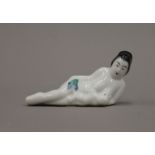 A late 19th/early 20th century Oriental porcelain figure of a mother feeding her baby. 10 cm long.