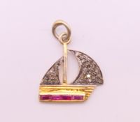 A diamond and ruby sailing boat form charm. 1.5 cm high.