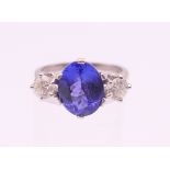 An 18 ct white gold diamond and tanzanite trilogy ring. Tanzanite approximately 1.