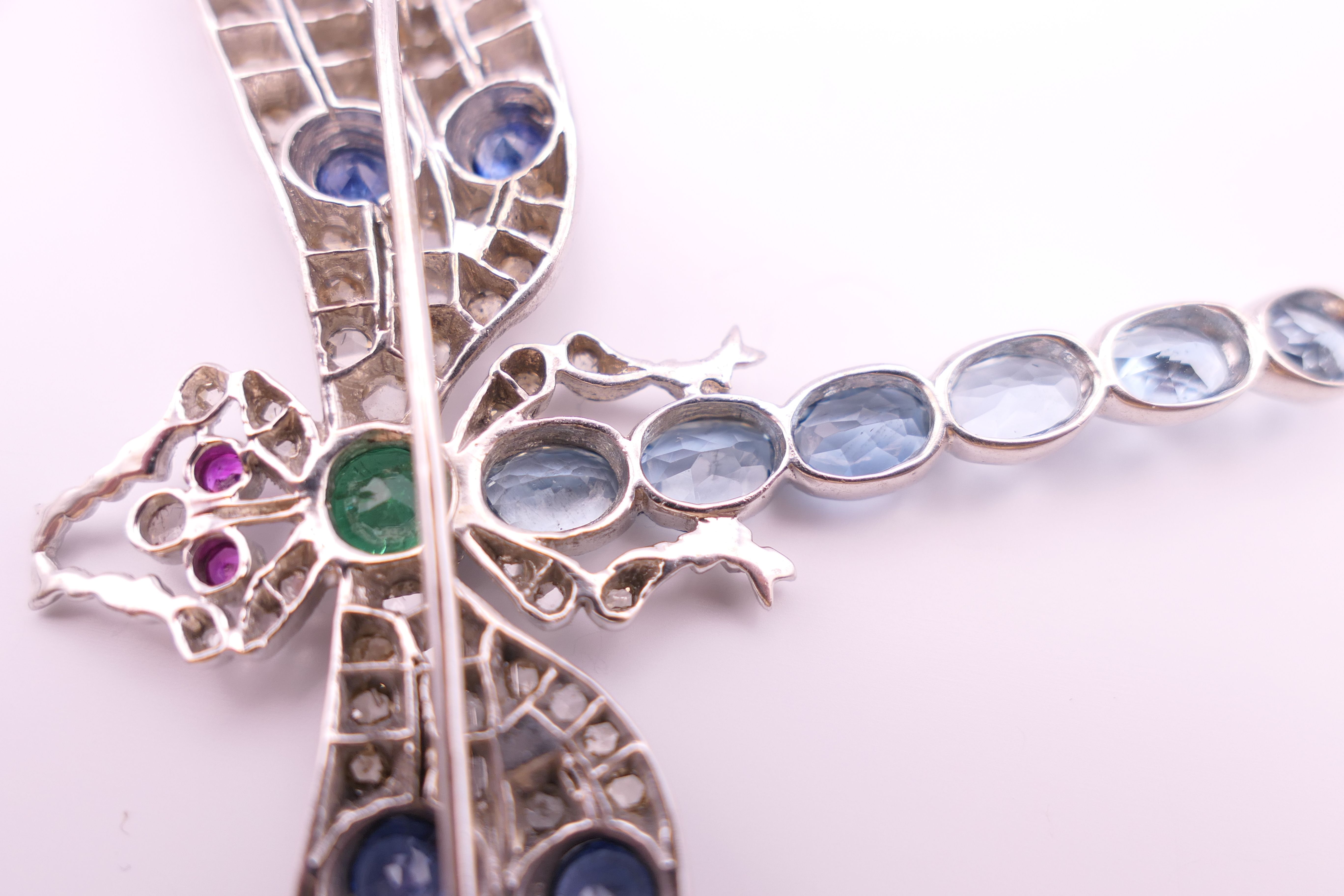 An unmarked 18 ct white gold dragonfly form diamond, sapphire, ruby, emerald and aquamarine brooch. - Image 11 of 11