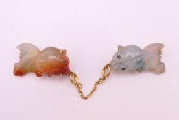 A Chinese gold and jade brooch formed as two fish. Each fish 2.5 cm long.