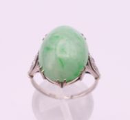 An 18 ct white gold and platinum cabochon jade and diamond ring. Ring size O/P.