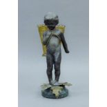 A figure of a young child carrying a basket. 19 cm high.