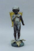 A figure of a young child carrying a basket. 19 cm high.
