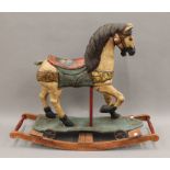 A painted wooden rocking horse. Approximately 88 cm long.