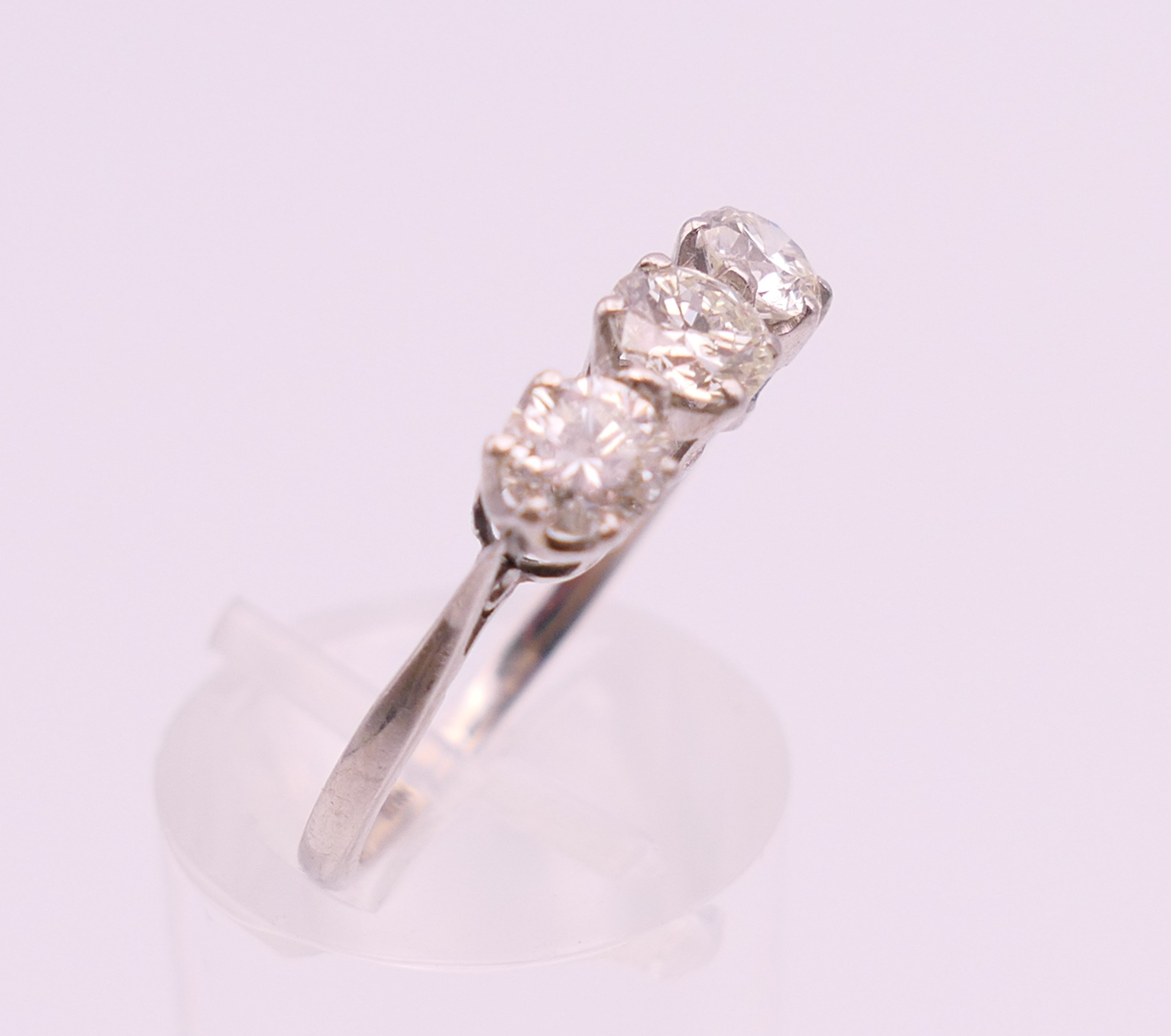 A platinum diamond trilogy ring. The total diamond weight approximately .8 carat. estimate. - Image 3 of 8