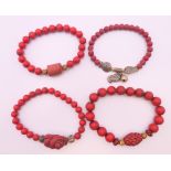 Four Chinese cinnabar bracelets.