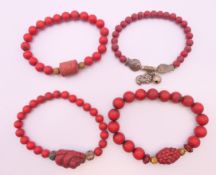 Four Chinese cinnabar bracelets.