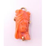 An 18 ct gold mounted coral pendant. 2 cm high.