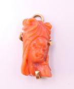 An 18 ct gold mounted coral pendant. 2 cm high.