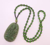 A jade pendant necklace. Pendant 6 cm high, necklace 64 cm long.