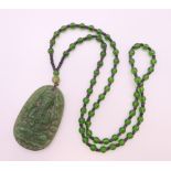 A jade pendant necklace. Pendant 6 cm high, necklace 64 cm long.