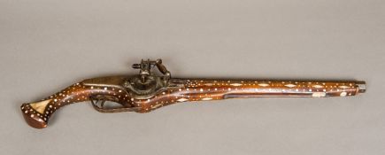 A bone and mother-of-pearl inlaid wheel lock pistol. 63.5 cm long.