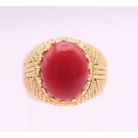 An 18 ct gold cabochon coral set ring. Ring size N/O.