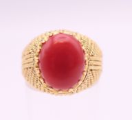 An 18 ct gold cabochon coral set ring. Ring size N/O.