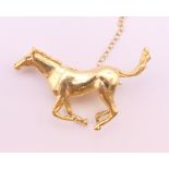 An 18 ct gold galloping horse form brooch. 3.75 cm wide x 2.5 cm high. 12.5 grammes.