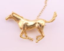 An 18 ct gold galloping horse form brooch. 3.75 cm wide x 2.5 cm high. 12.5 grammes.