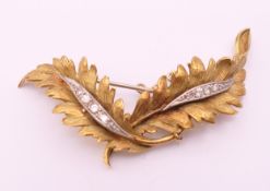 A Continental gold and diamond leaf form brooch. 5.5 cm long. 11.5 grammes total weight.