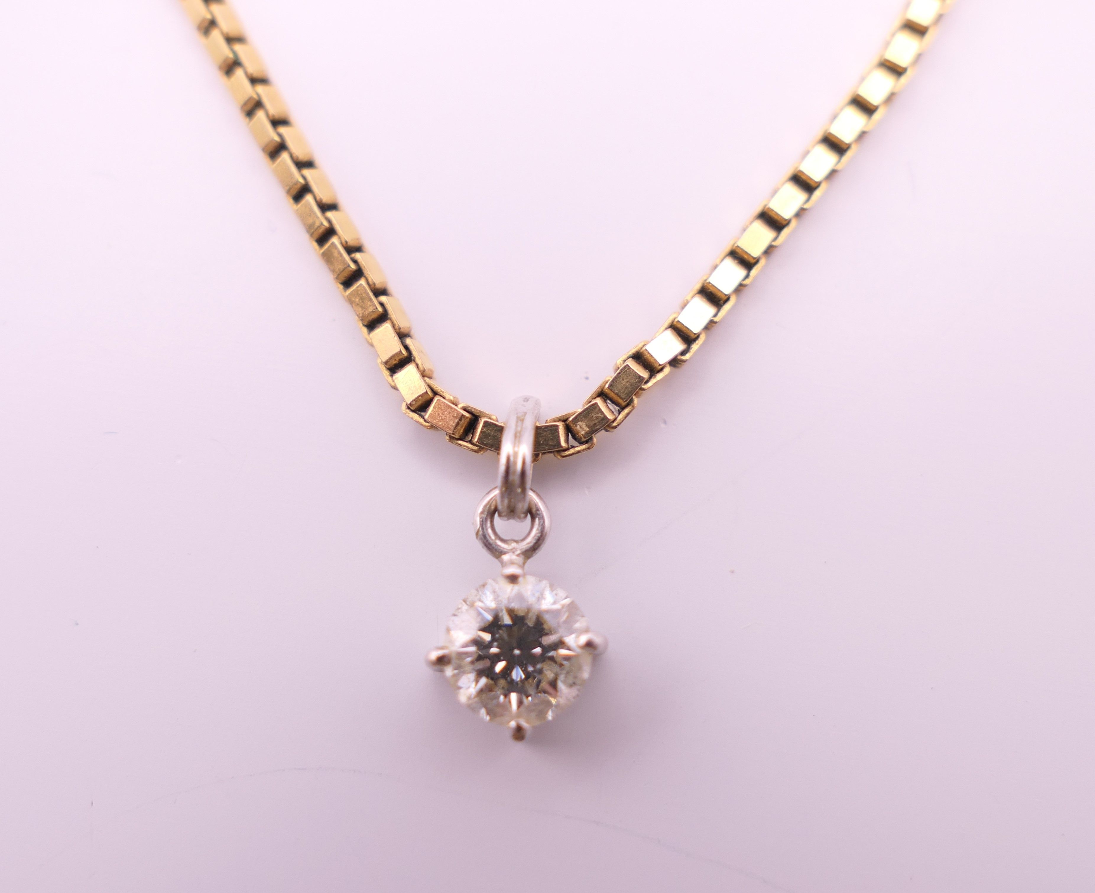 A diamond pendant on a 9 ct gold chain. Pendant 0.5 cm diameter, chain 40 cm long. 5.