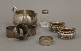 A silver cream jug, napkin rings and two salts. The former 12.5 cm long. 198.9 grammes.