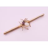 A 9 ct gold opal and ruby spider form brooch. 7.75 cm long. 6.1 grammes total weight.
