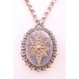 A silver locket on a long silver chain. Locket 5 cm high. 56.1 grammes.