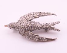 An unmarked gold backed silver swallow form brooch. 3.5 cm long.