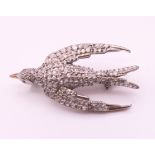 An unmarked gold backed silver swallow form brooch. 3.5 cm long.