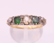 An 18 ct gold diamond and emerald five stone ring Ring size N.