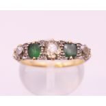 An 18 ct gold diamond and emerald five stone ring Ring size N.