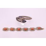 A Chinese enamel decorated dragon bracelet and a coral bracelet. Coral bracelet 19.5 cm long.