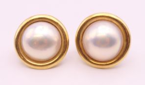 A pair of 9 ct gold and pearl earrings. 2 cm diameter.