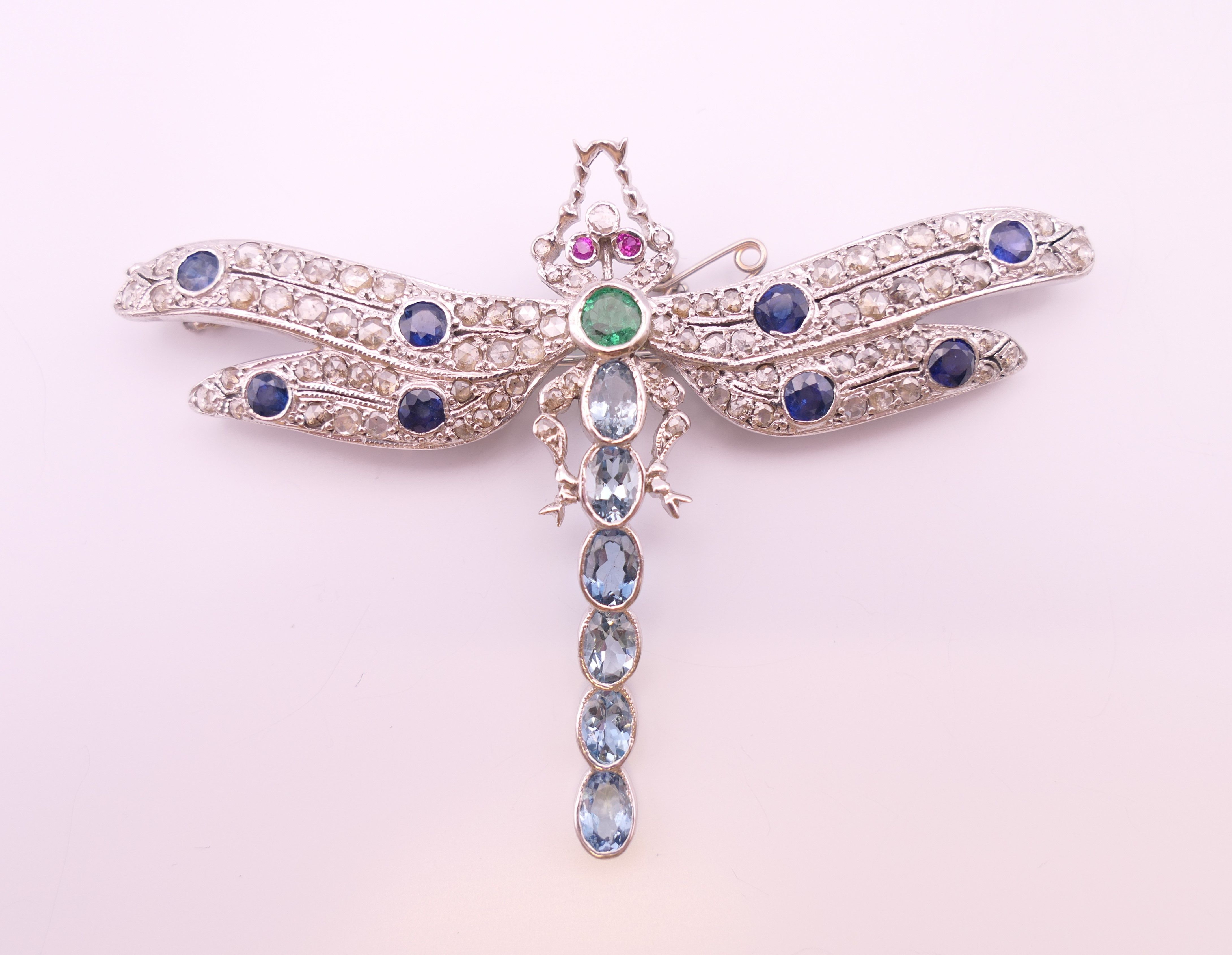 An unmarked 18 ct white gold dragonfly form diamond, sapphire, ruby, emerald and aquamarine brooch. - Image 2 of 11