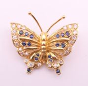 An 18 ct gold, diamond and sapphire butterfly form brooch. 2.5 cm wide. 4.7 grammes total weight.