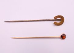 A 15 ct gold horseshoe stick pin and another. Horseshoe pin 5.5 cm long. 1.5 grammes total weight.