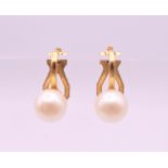 A pair of pearl earrings. Approximately 0.5 cm diameter.