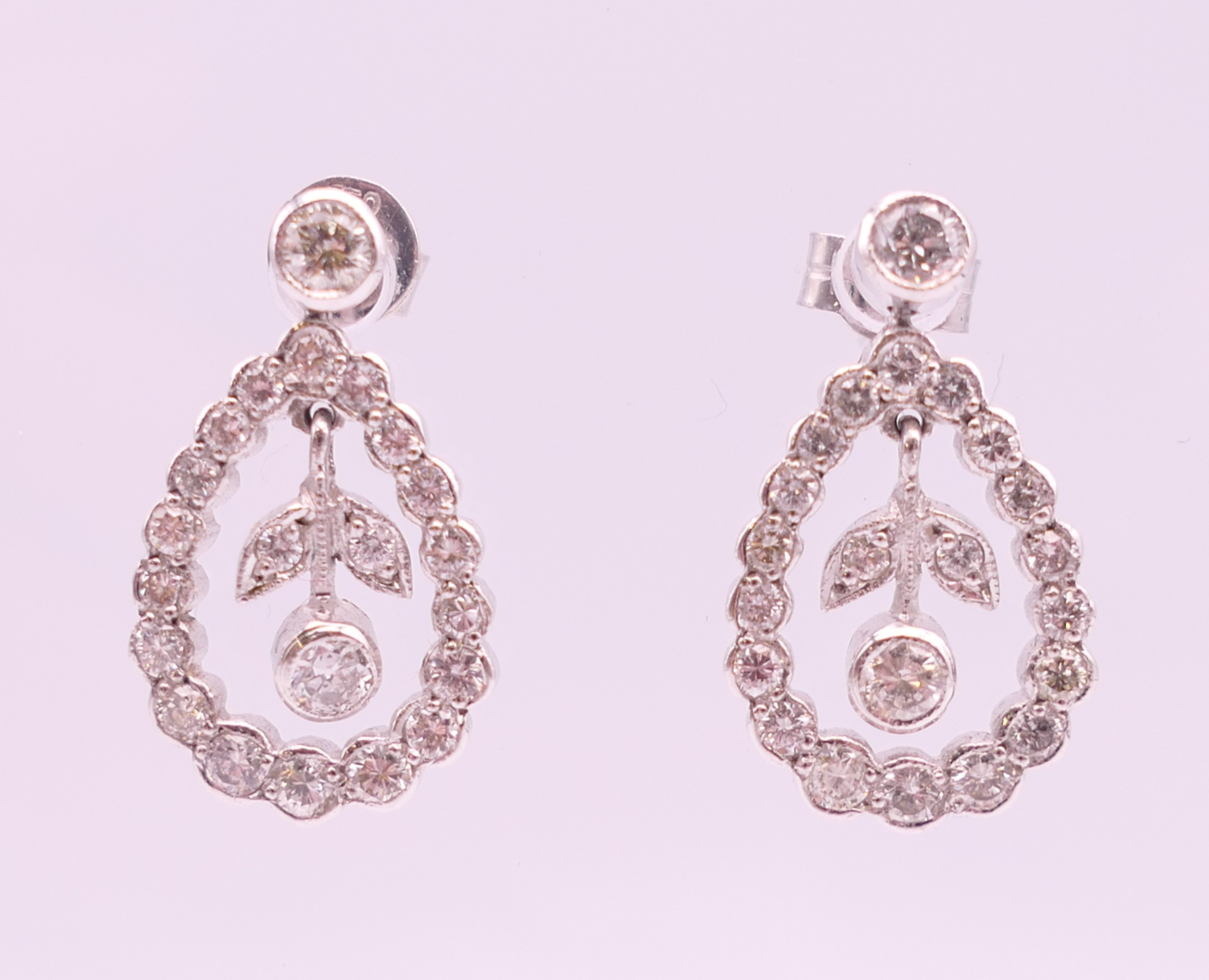 A pair of 18 ct white gold ''floral'' hoop drop earrings. 2 cm high.