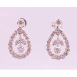 A pair of 18 ct white gold ''floral'' hoop drop earrings. 2 cm high.