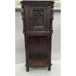 A 19th century carved oak side cupboard. 135 cm high.