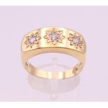 An 18 ct gold three stone diamond gypsy set ring. Ring size S/T. 8.8 grammes total weight.