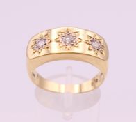 An 18 ct gold three stone diamond gypsy set ring. Ring size S/T. 8.8 grammes total weight.