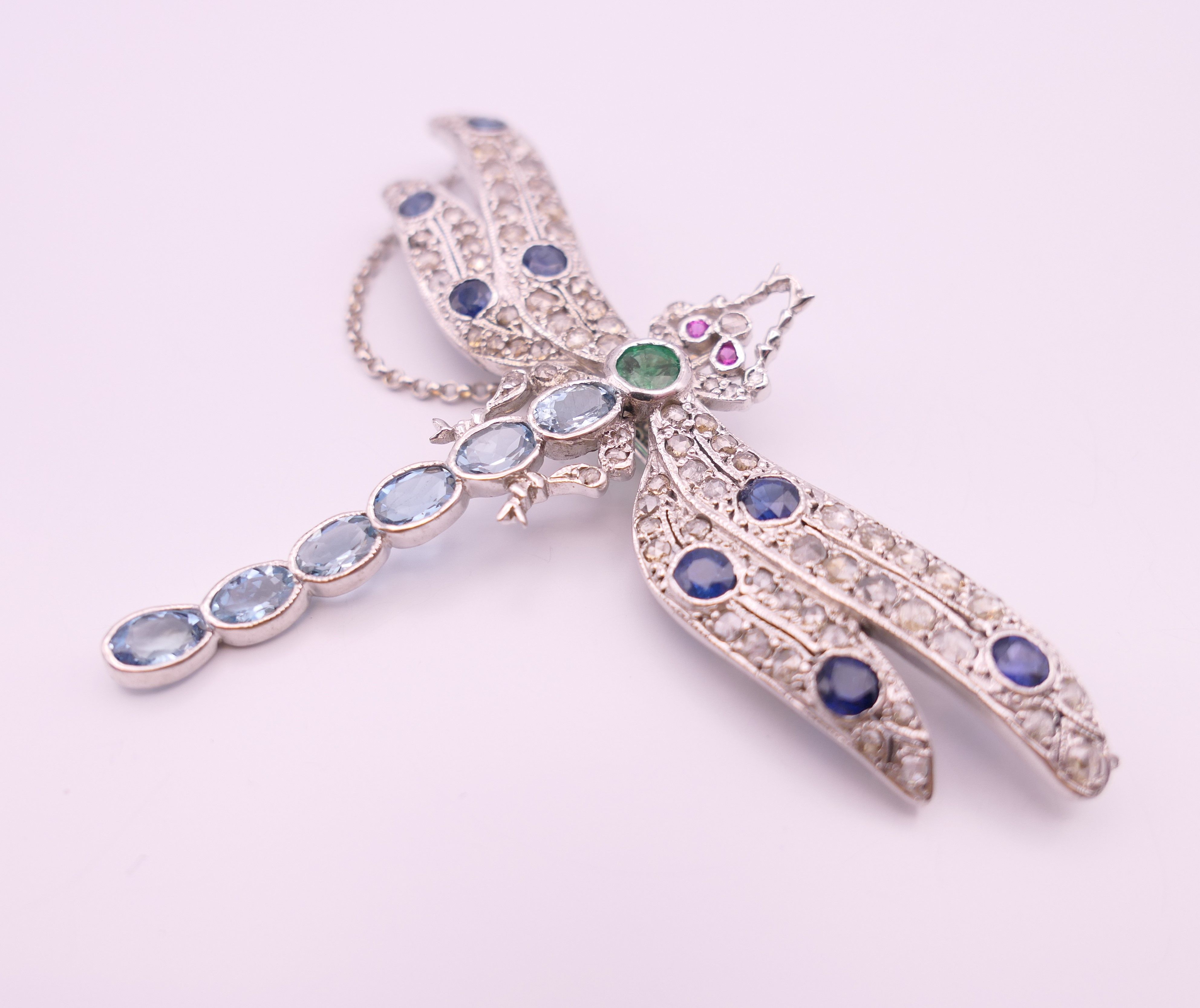 An unmarked 18 ct white gold dragonfly form diamond, sapphire, ruby, emerald and aquamarine brooch. - Image 5 of 11