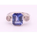 An 18 ct white gold diamond and emerald cut tanzanite ring.