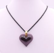 A Lalique amethyst glass heart shaped pendant, boxed. 3.25 cm high.