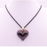 A Lalique amethyst glass heart shaped pendant, boxed. 3.25 cm high.