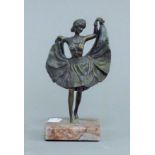 A bronze model of a dancing girl with lifted skirt. 15.5 cm high.